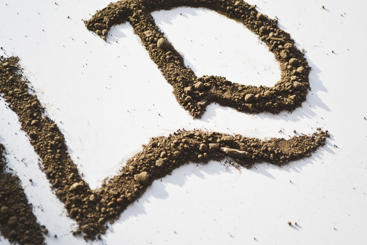 close up of letters spelled and drawn with dirt